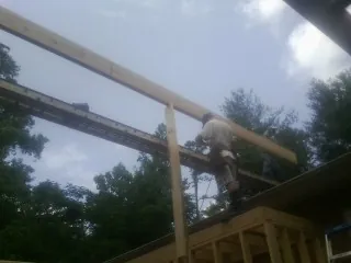 Carpenter setting a ridge beam over a new addition frame — Ice Dam Removal by Roofing Brothers in Karthaus
