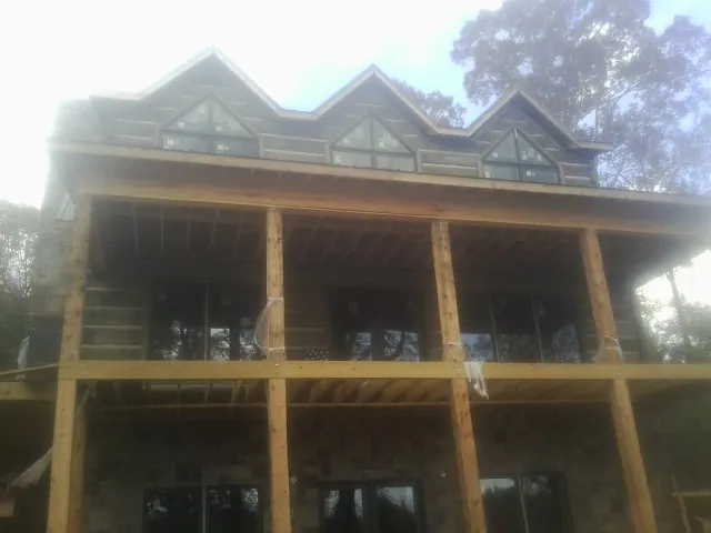 Dormers and porch framing on a large log home under construction — Roof Coating work by our crew in Karthaus
