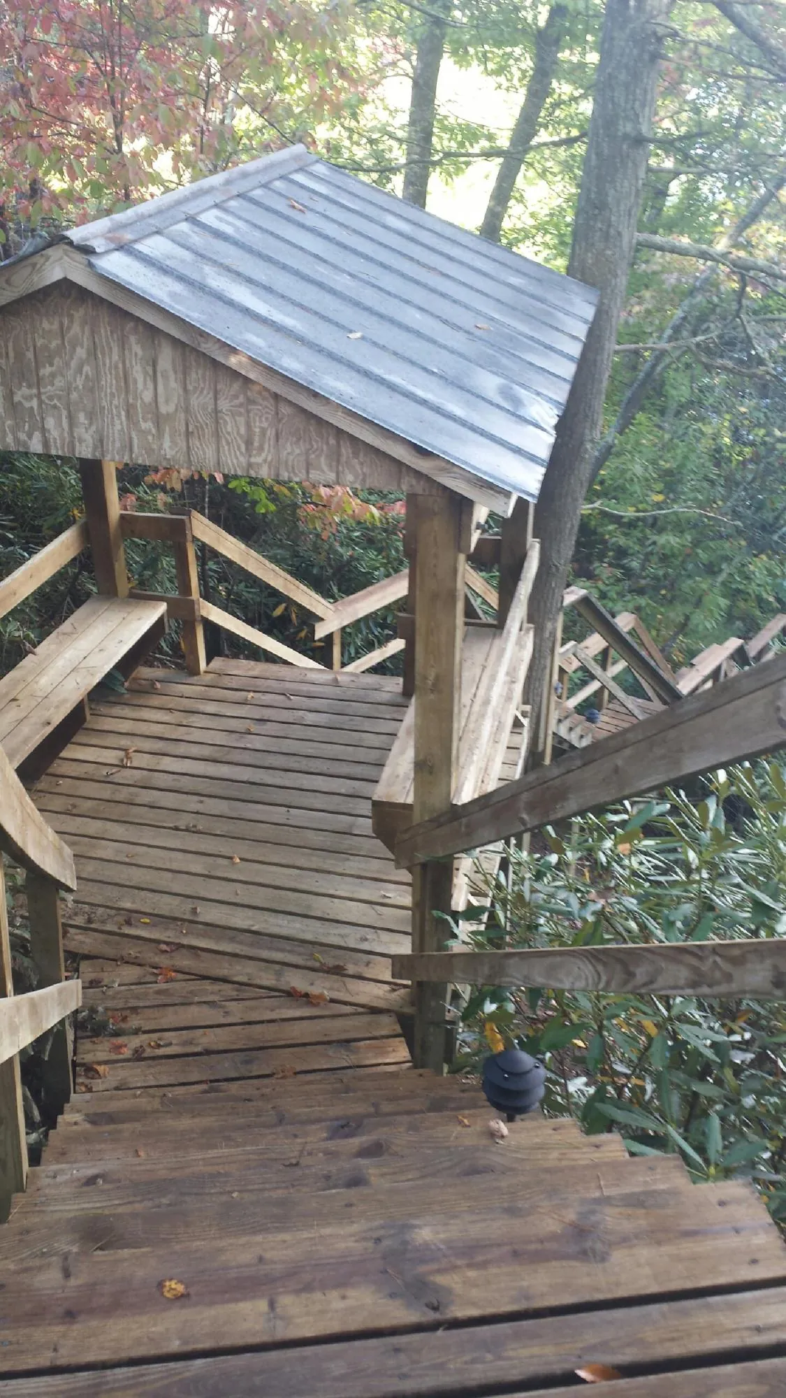 Metal roofed shelter over wooden steps on a wooded walkway — Skylight Repair & Installation work by our crew in Karthaus