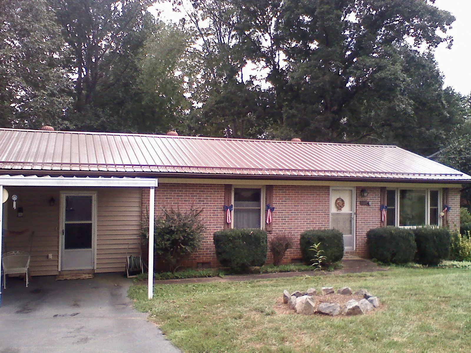Bronze metal roof and carport on a brick ranch home — Roof Repair work by our crew in Karthaus